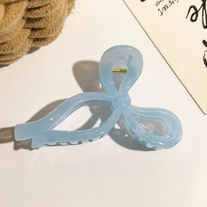 Gros plan sur la pince à cheveux papillon bleu clair translucide avec ressort doré
