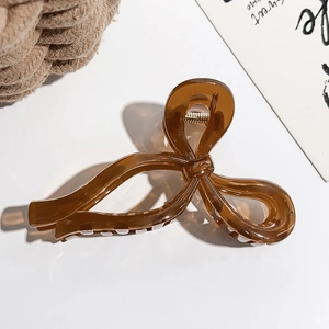 Détail de la pince à cheveux noeud ambrée translucide avec ressort en métal argenté