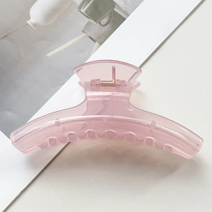 Gros plan sur la grande pince à cheveux rose translucide avec ressort métallique