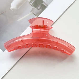 Détail de la grande pince à cheveux en acrylique rose corail avec ressort doré