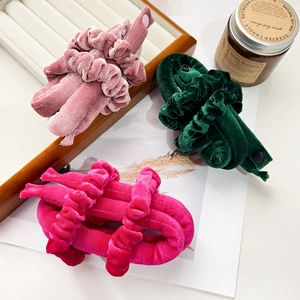 Detail van fluwelen hittevrije krullers in roze en groen op een decoratief dienblad