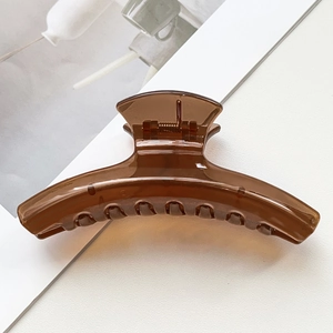 Détail d'une pince à cheveux ambre foncé avec une finition en résine transparente