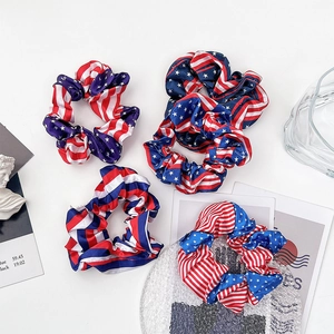 Detailansicht von vier Haargummis im USA-Flaggen-Design aus glänzendem Satin-Stoff
