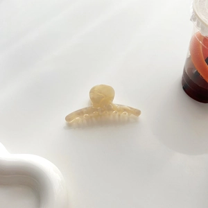 Gros plan détaillé d'une petite pince à cheveux en acétate marbré aux tons crème et brun