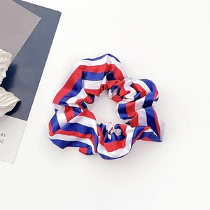 Detail von rot, weiß und blau gestreiftem Haargummi aus Satin im US-Flaggen-Stil auf Weiß
