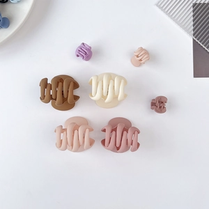 Ensemble détaillé de pinces à cheveux mates aux tons Morandi sur fond minimaliste chic
