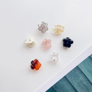 Vue détaillée de dessus de sept mini-pinces à cheveux fleurs colorées disposées en cercle