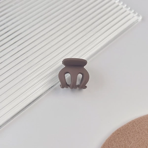 Vue détaillée de la mini pince à cheveux marron mat avec dents arrondies lisses