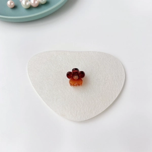 Détail de mini pince à cheveux fleur ambre sur feutre en forme de cœur blanc et perles