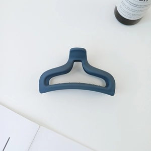 Macro detail of the dark blue matte hair claw clip with its non-slip hollow structure