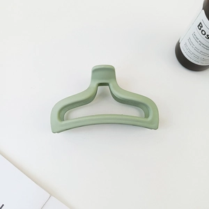 Detailed view of a light green matte mermaid tail hair claw clip in a Korean minimal aesthetic