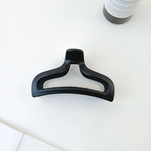 Detail of matte black hollow mermaid tail hair claw clip on clean white background