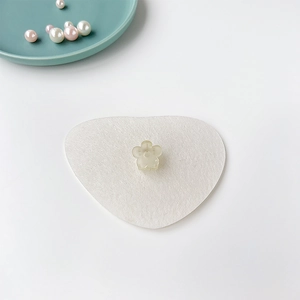 Vue détaillée d'une mini pince à cheveux fleur en résine blanc crème sur carte