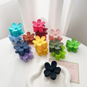 Macro detail of matte flower hair claws in colorful candy tones on a white surface