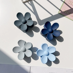 Matte flower hair claws in assorted blue tones on a clean minimalist background