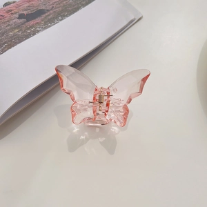 Close-up of translucent pink butterfly hair claw with durable gold metal spring