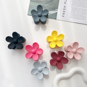 Set of matte flower hair clips in seven colors like dusty blue and pink on white background