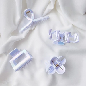 Iridescent pastel hair claw clip set in four unique shapes on white fabric background