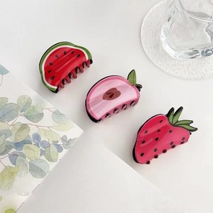 Detailed view of acrylic hair claws in cute watermelon, strawberry and apple shapes