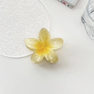 Detail of yellow gradient frangipani flower hair claw with translucent resin petals