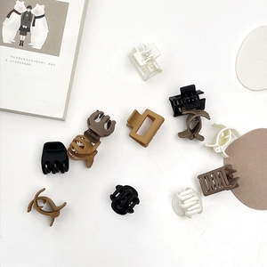 Flat lay of matte hair clips in neutral tones like cream, mocha, and dark brown