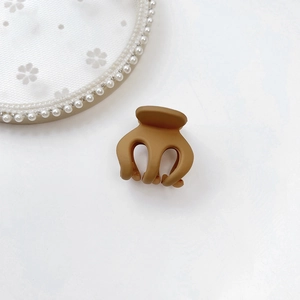 Detail shot showing the matte coffee brown mini hair claw clip for high ponytail styling