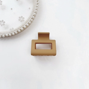 Close-up of matte khaki square hair claw clip with a sleek minimalist frosted finish