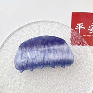 Detail view of the blue-purple marbled acrylic hair claw clip with a semi-circular design