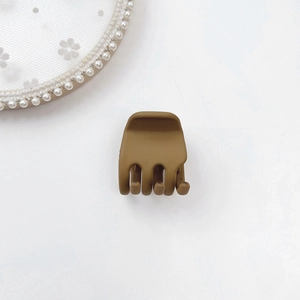 Detailed top view of a matte caramel mini hair claw clip for side bangs and high ponytails