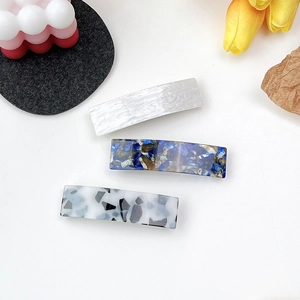 Three elegant tortoiseshell acetate rectangular hair clips with marble patterns
