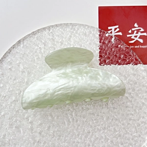 Detailed top view of light green marble acrylic hair claw clip with smooth texture