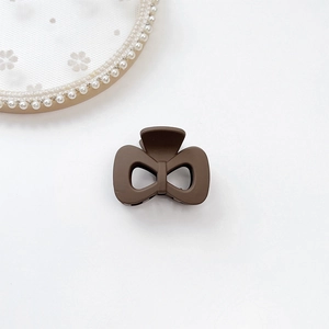 Close-up of a mocha brown matte bow-shaped hair claw clip on a white background