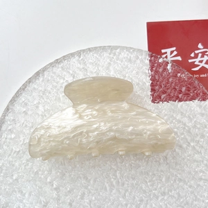 Detailed close-up of cream marble acrylic hair claw clip with smooth polished texture