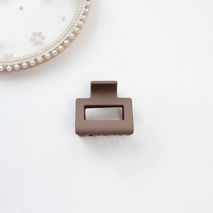 Close-up of matte dark khaki square hair claw clip with strong spring on white lace
