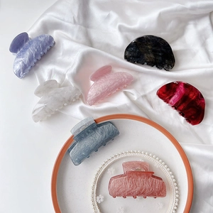 Detailed macro view of assorted acetate hair claws with premium marble pattern textures