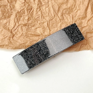 Macro detail of French style rectangular acetate hair clip with silver glitter stripes