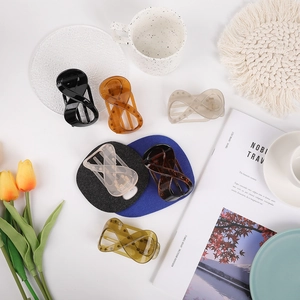 Flat lay of minimalist figure-eight hair claws in multiple colors on a white background