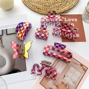 Flat lay of iridescent checkerboard hair claws in various geometric shapes and styles
