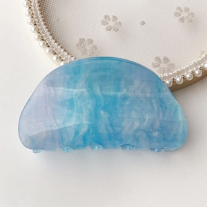 Detail of blue marble cellulose acetate hair claw with silver glitter and rounded edges