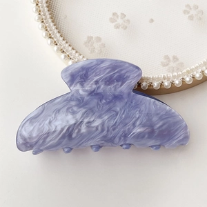 Detail of lavender marble acetate hair claw clip on an elegant pearl lace tray