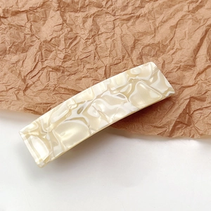 Detail view of square marble pattern hair clip with creamy shell finish and smooth texture