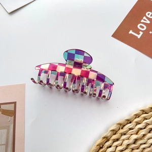 Macro shot of large acetate shark hair claw clip with colorful iridescent checkerboard pattern