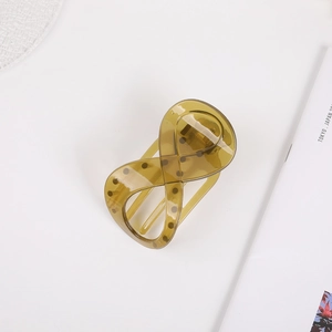 Detail view of the olive green resin hair claw clip with its elegant cross-ring design