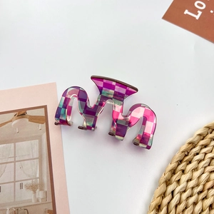 Macro shot of colorful checkered pattern acetate hair claw clip with wavy edges