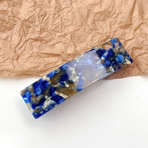 Close-up of elegant marble pattern acetate hair clip with polished tortoiseshell finish