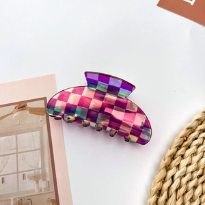 Macro detail of aurora gradient checkerboard hair claw made of premium acetate