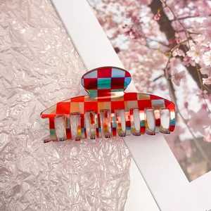 Macro detail of iridescent checkered acetate claw clip with holographic hair accessory finish