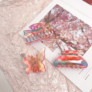 Close-up of pink checkered acetate hair claws in butterfly and geometric shapes