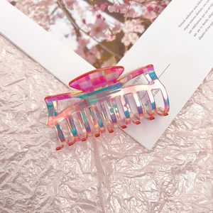 Detail of pink checkerboard hair claw clip with iridescent finish and resin texture