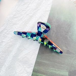 Macro shot of checkered acetate hair claw clip with colorful translucent patterns and metal spring